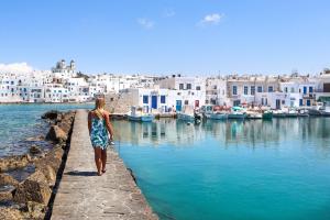 a woman walking along a pier near a harbor at Amphitrite's Haven - Cycladic House in Marpissa, Paros in Márpissa