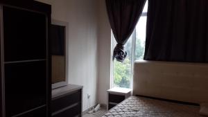 Dormitorio con ventana, cama y TV en Equine Park, Seri Kembangan, en Seri Kembangan