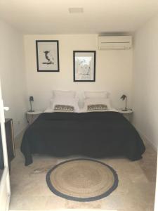 una camera da letto con un grande letto con una coperta nera di les Chambres d'Amis a Sanary-sur-Mer