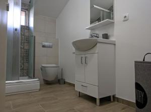 a white bathroom with a sink and a toilet at Villa Longina in Ljubuški