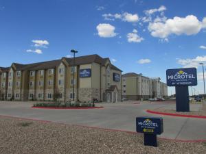 a hotel with a sign in front of a building at Microtel Inn & Suites by Wyndham in Midland