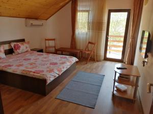 a bedroom with a bed and a table and a door at Casa David&Alexia 2 Mai in 2 Mai