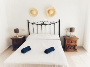a bedroom with a bed with two blue pillows on it at Casa Barbados en Agua Amarga in Agua Amarga