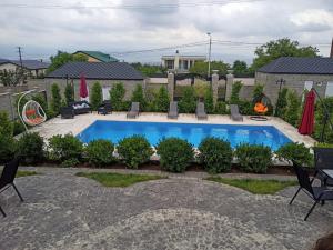 una piscina en un patio trasero con sillas y mesa en Shindisi Residence Boutique Villa en Tiflis