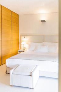Un dormitorio blanco con una gran cama blanca y un cajón en MUSE Saint Tropez - Small Luxury Hotels of the World en Saint-Tropez