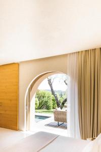 a bedroom with a bed and a window at MUSE Saint Tropez - Small Luxury Hotels of the World in Saint-Tropez