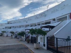 ein großes weißes Gebäude mit Bäumen davor in der Unterkunft Casa Barbados en Agua Amarga in Agua Amarga