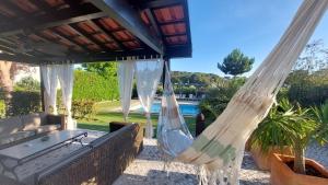 a hammock on a patio with a pool at VILLA DA FONTE - BY MECO in Alfarim