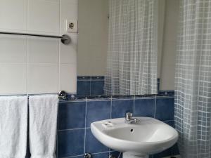 uma casa de banho com um lavatório branco e um espelho. em Pensao Lourenco em Curia
