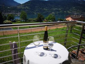 Tenna 的住宿－La Posada sul Colle，一张桌子上摆放着一瓶葡萄酒和酒杯