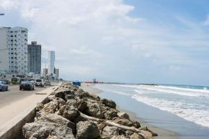 una playa con rocas y el océano y edificios en Apartamento Con vista al Mar B-3-9, en Cartagena de Indias