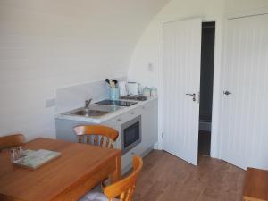 a kitchen with a table and a sink and a table and chairs at Ptarmigan in Nethy Bridge