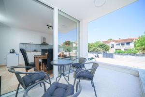 a room with chairs and a table and a kitchen at Vila Regina Apartment Paloma with Swimming Pool in Jezera