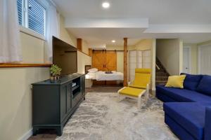 a living room with a blue couch and a bedroom at Adorable private suite with indoor fire place in Cochrane
