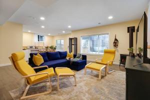 a living room with a blue couch and yellow chairs at Adorable private suite with indoor fire place in Cochrane