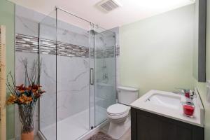 a bathroom with a shower and a toilet and a sink at Adorable private suite with indoor fire place in Cochrane