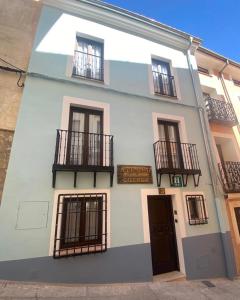 un edificio bianco con balconi neri e una porta di Ateneo Cuenca a Cuenca
