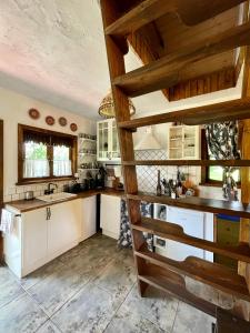 a kitchen with white cabinets and wooden ceilings at Chata w Ciszy in Uście
