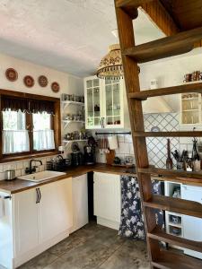 a kitchen with white cabinets and a wooden ladder at Chata w Ciszy in Uście +23 photos