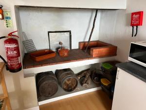 a kitchen with a shelf with pots and pans at Rosa do Canto in Monte