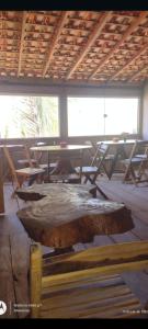 una mesa de madera en una habitación con mesas y sillas en Pousada Shalon e Hostel Holly Land, en Santo Amaro