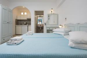 two beds in a white room with towels on them at Castello on the Beach in Agia Anna Naxos