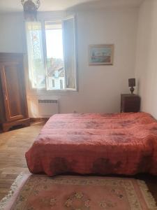 a bedroom with a large red bed with a window at Maison Bourgogne in Château-Chinon +35 photos