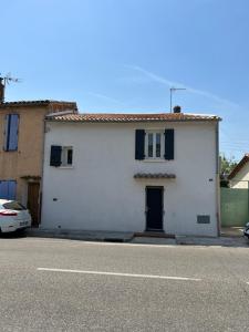 耶尔Petite maison cosy et moderne avec bain à remous的街上有一扇蓝色门的白色房子