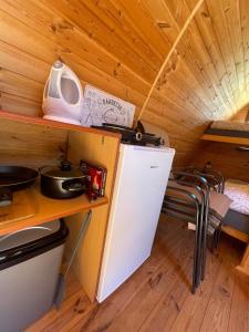 a small kitchen with a refrigerator in a tiny house at Hobití chatka Lipno in Černá v Pošumaví