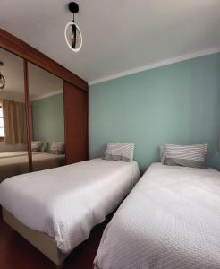 2 Betten in einem Zimmer mit Spiegel in der Unterkunft Parfum de la Mer in Sines