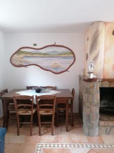 a dining room with a table and a fireplace at Casa vacanze Lilly in Teulada