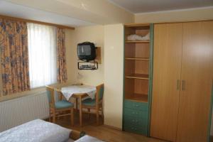 a room with a bedroom with a table and a tv at Gasthof Bauer in Steyr