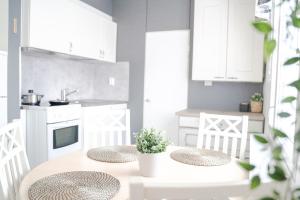 uma cozinha com armários brancos e uma mesa com duas cadeiras em West Coast Hideaway em Pietarsaari