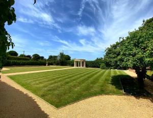 a large grass field with a building in the background at The Old Rectory in Deal