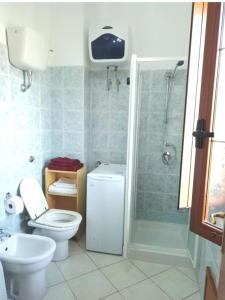 Un baño con ducha, inodoro y lavabo. en Prendas Antigas - vacanze a Teulada, en Teulada