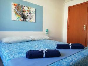 Un dormitorio con dos camas con sábanas azules. en Prendas Antigas - vacanze a Teulada, en Teulada