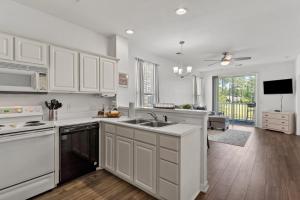 a kitchen with white cabinets and a sink at Tee Time in Sunset Beach