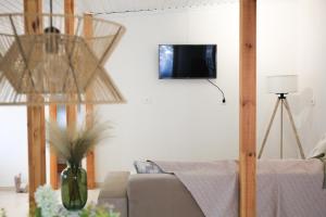 a living room with a couch and a tv on a wall at LAXD Summer House by Homebrain in Makri