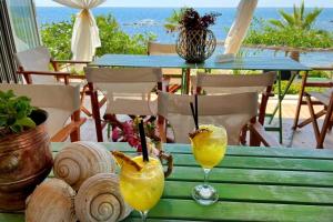 a table with two glasses of orange juice on it at Kallmi View Eco Rooms in Durrës