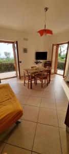 a living room with a table and chairs and a television at PraiadAmare in Praia a Mare