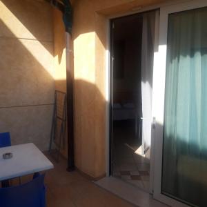 uma porta de vidro deslizante para um quarto com uma mesa em Residence Rosemary em Brenzone sul Garda