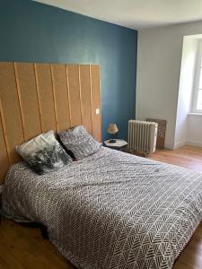 ein Schlafzimmer mit einem Bett mit zwei Kissen darauf in der Unterkunft La maison de Badet in Bozouls