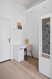 een witte kamer met een bureau en een stoel bij *Lasuite #2 YELLOW* in Valenciennes