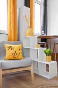 een geel kussen zittend op een stoel in een kamer bij *Lasuite #2 YELLOW* in Valenciennes
