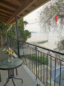 einen Balkon mit einem Tisch und Blick auf das Wasser in der Unterkunft MARINA in Perama