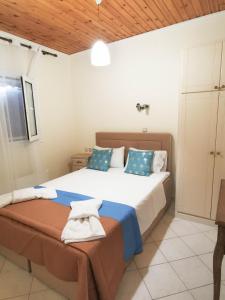 1 dormitorio con 1 cama grande con almohadas azules y blancas en MARINA, en Perama