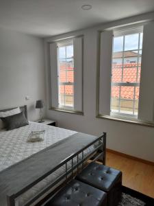 una camera con un grande letto e due finestre di Cantinho do Rio a Ponte da Barca