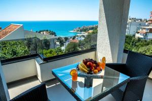 a bowl of fruit on a glass table on a balcony at Golden Apartments in Ulcinj