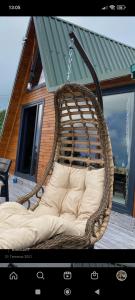 a wicker chair hanging from a porch in front of a house at LOVA BUNGALOV in Ardeşen