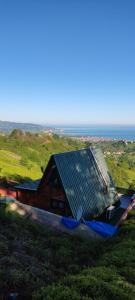 ein Haus mit einem Blechdach auf einem Hügel in der Unterkunft LOVA BUNGALOV in Ardeşen